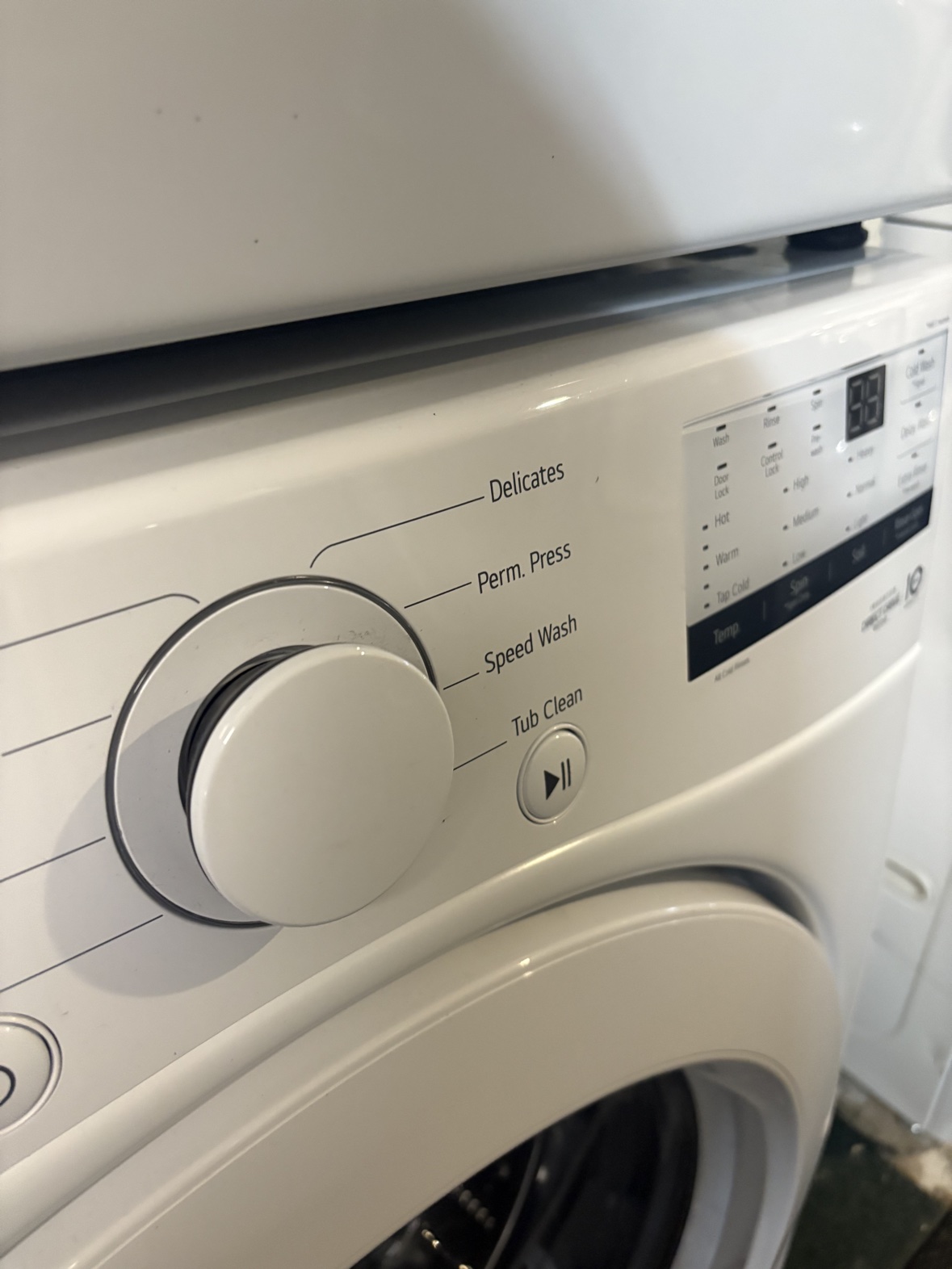 LG white front-load washer control panel with cycle dial and digital display