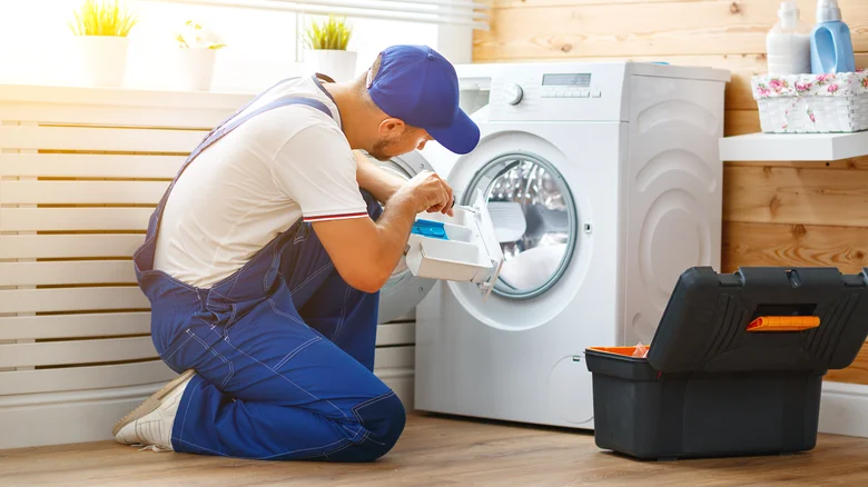 Appliance repair technician servicing a front-load washing machine
