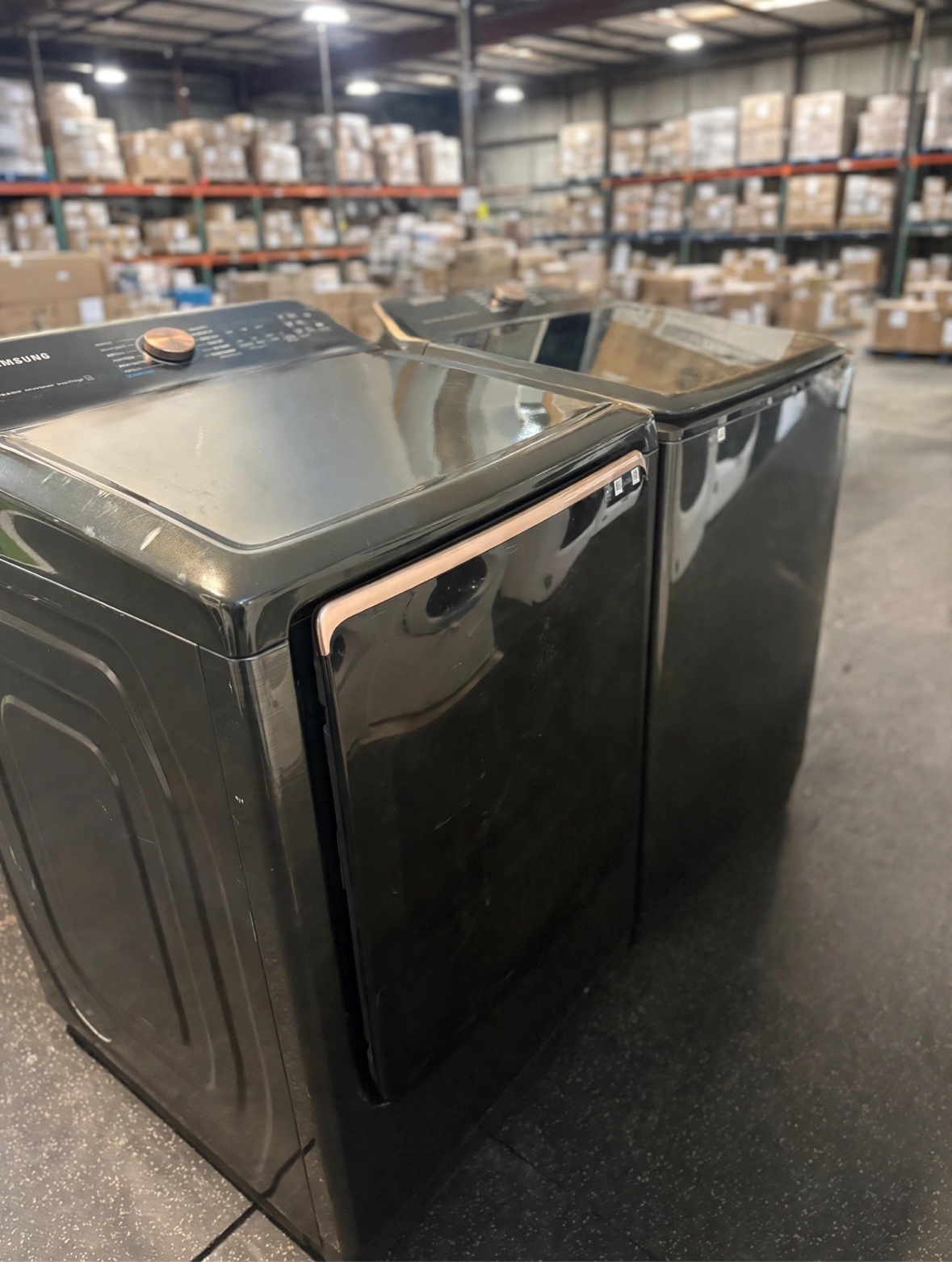 Black stainless Samsung top-load washer and dryer set with rose gold dials